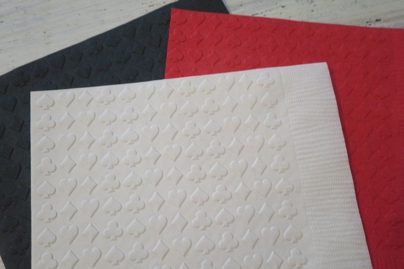 Puede incluir: Tres hojas de cartulina texturizada en negro, rojo y blanco. Cada hoja tiene un patr&oacute;n repetido de s&iacute;mbolos de cartas de juego.