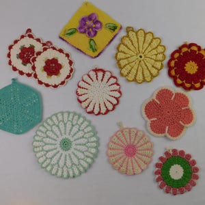 May include: A white ceramic mug with a black handle and the text "But First, Coffee" in a black, handwritten-style font. The mug is on a white surface.