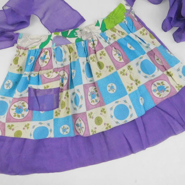 Vintage reversible half apron with purple, green teal floral elements with pocket. Two layers of fabric. 1950s hostess kitchen waist apron.