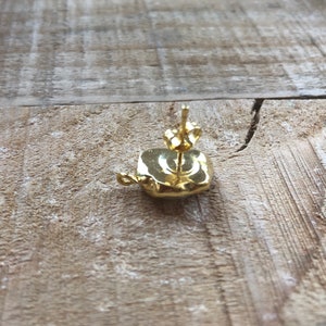 May include: Gold square shaped earring with a post and butterfly back.
