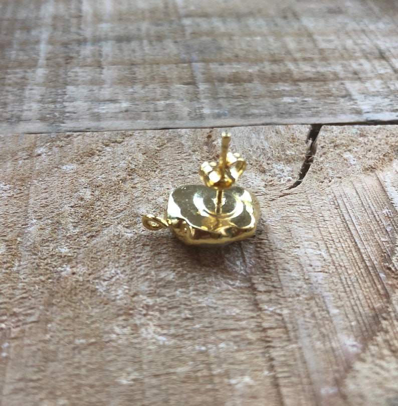 May include: Gold square shaped earring with a post and butterfly back.