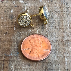 May include: Gold tone earring findings with a clear crystal stone. The findings have a loop on the top and a post on the bottom.