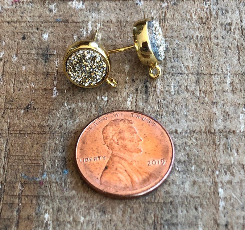 May include: Gold tone earring findings with a clear crystal stone. The findings have a loop on the top and a post on the bottom.
