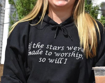 Puede incluir: Una sudadera con capucha negra con un gráfico blanco que dice "if the stars were made to worship, so will I".