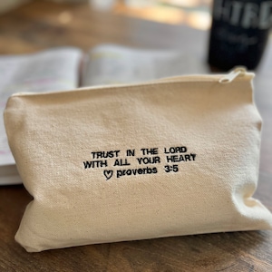 Peut inclure: Une pochette zipp&eacute;e en toile blanche avec le texte brod&eacute; "Trust in the Lord with all your heart Proverbs 3:5"