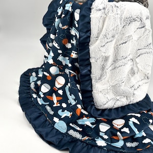 Manta de bebê vintage com estampa de avião, macia e aconchegante, ideal para o quarto do bebê ou para o carrinho de bebê. Perfeita para decorar o berçário e o quarto com tema de aventura, transporte e segurança.