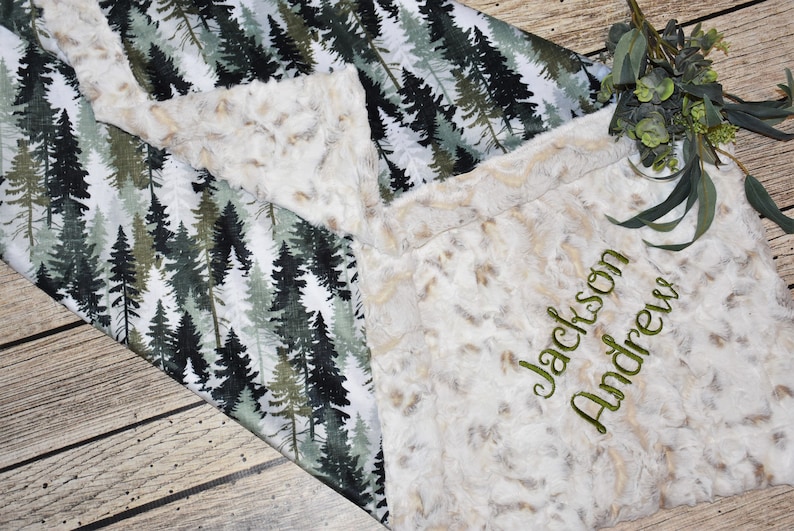 Elevate your nursery décor with a boy minky blanket, featuring delicate pine trees and a fawn motif. This green baby gift is a symbol of comfort and style