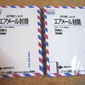 以下が含まれることがあります： 赤と青のストライプの白い封筒が2パック。封筒には「エアメール」と日本語で「のり不要ワンタッチ」と書いてあります。封筒の前面には「エアメール封筒、サイズ114×162mm、30枚入り」と書いてあります。