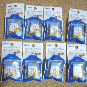 以下が含まれることがあります： 富士山消しゴムと書いてある、小さな山型の消しゴムが10個、個包装されたセットです。消しゴムは白地に青と金の模様で、かわいらしいデザインです。