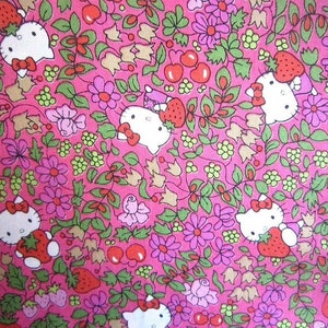 Może przedstawiać: Różowy materiał z powtarzającym się wzorem białych postaci Hello Kitty, truskawek, kwiatów i liści.