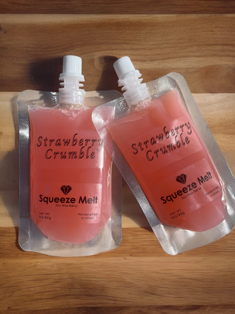 Puede incluir: Dos bolsas de cera de soja con aroma a crumble de fresa. Cada bolsa est&aacute; etiquetada con "Strawberry Crumble" y "Squeeze Melt Soy Wax Blend" con un logotipo de diamante. Las bolsas son de 3 oz (85g) y est&aacute;n hechas a mano en Illinois.