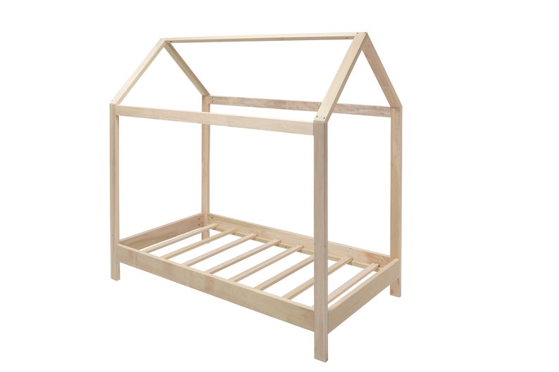 May include: A light-colored wooden bed frame featuring a house-shaped structure with a peaked roof design. The frame is constructed from smooth, unfinished wood beams and includes a slatted base for support, showcasing a simple, open-concept design.
