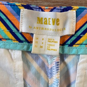 May include: A white tag with the text "Maeve by Anthropologie" in gold lettering. The tag also includes size information: UK 8, US 4, EU 36. The tag states "Made in Philippines" and "Fabriqu&eacute; aux Philippines".