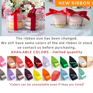 May include: Two clear boxes with macarons inside. The boxes are tied with red ribbon. The text "New Ribbon" and "Old Ribbon" is printed below each box. The text "NEW RIBBON SIZE" is printed at the top of the image. The text "The ribbon size has been changed. We still have some colors of the old ribbon in stock so contact us before purchasing." is printed below the boxes. The text "AVAILABLE COLORS - limited quantity" is printed below the text. A chart of ribbon colors is shown below the text. The text "*Colors can be unavailable even if they are listed*" is printed below the chart.