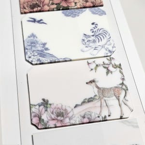 May include: Three rectangular acrylic plaques with clipped corners. The top plaque features pink peonies. The middle plaque displays a blue tiger, a bird, and floral elements. The bottom plaque shows a deer, pink flowers, and green foliage.