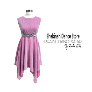 May include: A sleeveless, pink dance dress with a sparkly, textured fabric. The dress features a round neckline, a silver sequined belt, and an asymmetrical hemline. The text "Shekinah Dance Store PRAISE DANCEWEAR By Dalia SM" is printed on the right side.