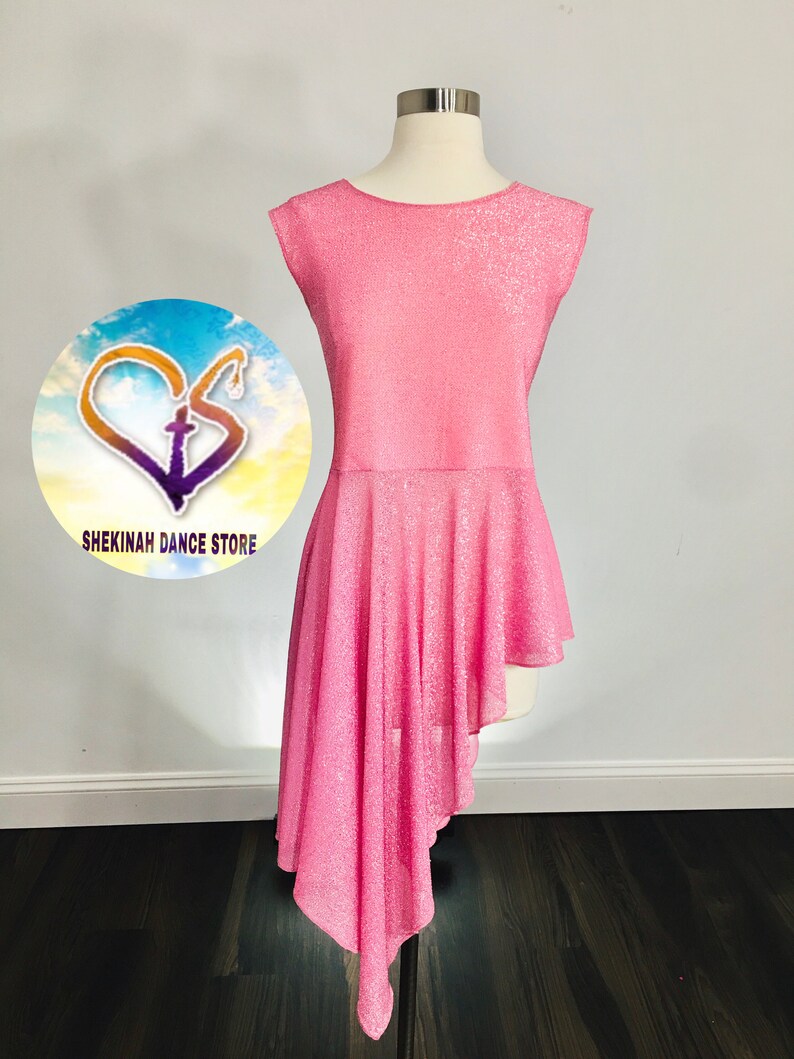 May include: Pink sleeveless dance top with a glittery finish and a high-low hemline. The top is asymmetrical, with one side longer than the other. The top is on a mannequin.