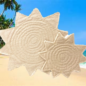 May include: Two beige star-shaped placemats with a spiral design in the center. The placemats are made of a textured material and are set against a beach background with palm trees and a blue sky.