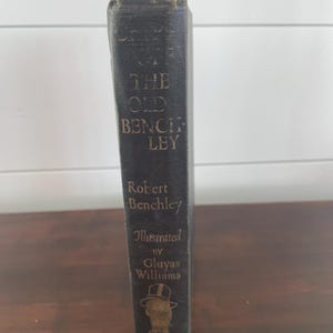 May include: A black hardcover book titled "The Old Benchley" by Robert Benchley, illustrated by Gluyas Williams. The book cover features a gold illustration of a man in a top hat.