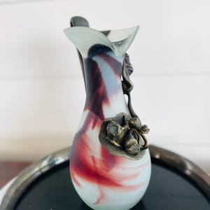 Può includere: Una tazza di ceramica bianca con manico nero e la scritta "But First, Coffee" in grassetto nero. La tazza è posta su uno sfondo sfocato, che suggerisce un'atmosfera accogliente.