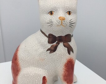 Chat en céramique avec noeud en bronze, minou en porcelaine, chat crème et orange craquelé