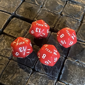 Puede incluir: Cuatro dados rojos con números y palabras blancas. Las palabras en los dados son "FUCK", "YEAH" y "YEAH".