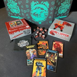 May include: A set of black and red dice with a black and white card game featuring a monster with a sword. The card game is called "Head Lopper Custom Dice Set". The cards feature illustrations of monsters and the text "Twerpal", "Agatha", "Norgal", "Berserkr", and "Zhaania".