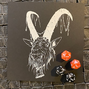 Puede incluir: Una ilustración en blanco y negro de una cabeza de cabra con cuernos, una campana y cadenas. La imagen está sobre un fondo negro. Hay cuatro dados en la imagen, dos rojos y dos negros. Los dados rojos tienen las palabras "FUCK" y "YEAH" en ellos. Los dados negros tienen los números 17, 19, 13, 3, 21, 15, 7, 19, 13, 21, 2, 18, 14, 2, 8 y 12 en ellos.