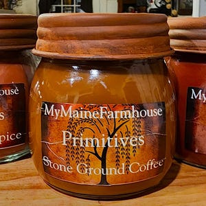 Peut inclure: Trois bocaux en verre avec des couvercles rouillés et des étiquettes. Les étiquettes sont brunes avec un motif d'arbre et le texte "MyMaineFarmhouse Primitives". Les bocaux sont remplis d'une substance brune et les étiquettes indiquent "Hearthside Spice", "Stone Ground Coffee" et "Fig Harvest".