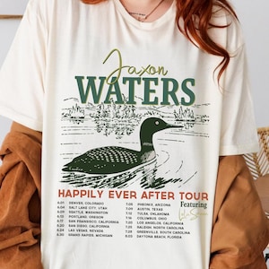 May include: A white t-shirt with a green and black graphic of a loon on a lake. The graphic includes the text "Jason Waters" and "Happily Ever After Tour". The tour dates and locations are listed below the graphic.