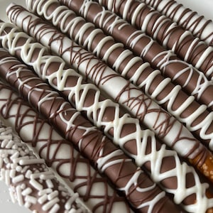 Chocolate Covered Pretzels! Decorated in white, milk and dark chocolate with sprinkles and beautiful drizzle!  Perfect wedding favor!