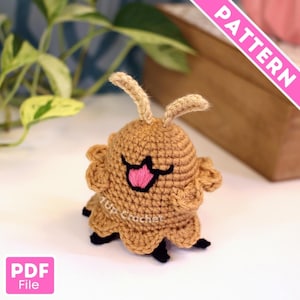 May include: A crocheted brown creature with a smiling face, pink tongue, and black accents. The handmade amigurumi has two antennae and a ruffled edge. The image includes the text "PATTERN" and "PDF File".