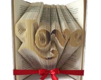 Liebesbuch Faltmuster. Machen Sie ein Hochzeits- oder Verlobungsgeschenk oder einzigartige Wohnkultur. Liebe Wortkunst / Buchskulptur. Kostenlose Anleitung