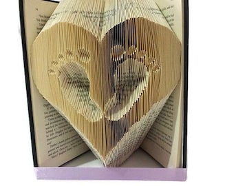 Babyfüße im Herzbuch Faltmuster. DIY Baby Geschenk. Erstellen Sie eine Buchskulptur für Babypartys, neues Baby oder Gedenkstätte. Kostenlose Anleitung