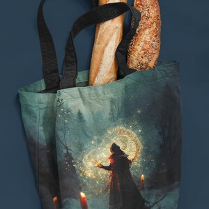 May include: A blue tote bag featuring a magical forest scene print. The bag is filled with two loaves of bread, one white and one with seeds.