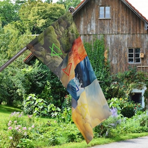 May include: A colorful flag with a geometric design. The flag is made of fabric and has a variety of colors, including green, orange, blue, and yellow. The flag is flying in the wind and is attached to a wooden pole.