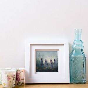 May include: A white picture frame with a mat and a print of a painting of three figures in a forest setting. The figures are wearing white robes and have flowers in their hands. The background is a soft blue and green.