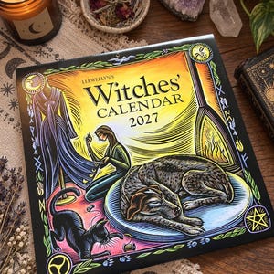 Peut inclure: Calendrier Llewellyn's Witches' Calendar 2027 avec une illustration colorée d'une personne cousant un vêtement, un chien endormi sur un tapis bleu et un chat noir jouant avec du fil, encadré par une bordure décorative avec des motifs de soleil.