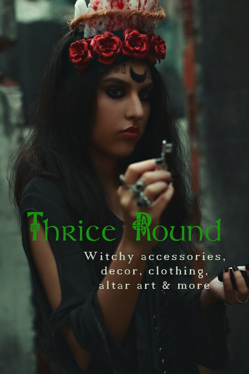 Puede incluir: Una mujer vestida con un atuendo negro y una corona de rosas rojas sostiene una llave de plata. El texto "Thrice Round" est&aacute; escrito en verde con un dise&ntilde;o de nudo celta. El texto debajo dice "Witchy accessories, decor, clothing, altar art & more".