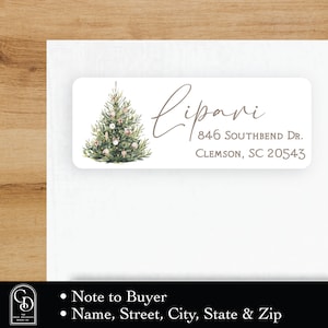 Puede incluir: Una etiqueta de devolución de dirección con temática navideña con una ilustración de acuarela de un árbol de Navidad decorado. El texto dice "Lipari, 846 Southbend Dr., Clemson, SC 20543".