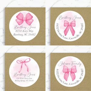 May include: Four round address labels with pink watercolor bows. The labels feature the text "Brittany Jones" and different addresses. One label features the text "Johnson Family".