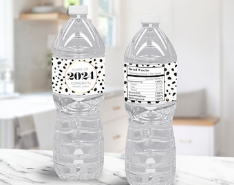Puede incluir: Dos botellas de agua de plástico transparente con etiquetas de lunares negros y blancos. La etiqueta de la botella de la izquierda dice "Class of 2024 Congrats, Hayden Jones". La etiqueta de la botella de la derecha dice "Grad Facts Diploma Giving 1 Per Grad Success Value Ceremony 100% Gown 33.7% Cap 33.3% Tassel 31.3% Success 100% Determination 100% Willingness 100%"