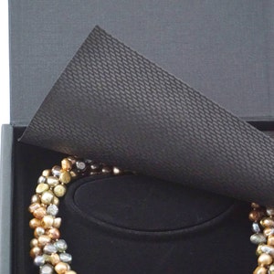The box includes protective flaps of black material.