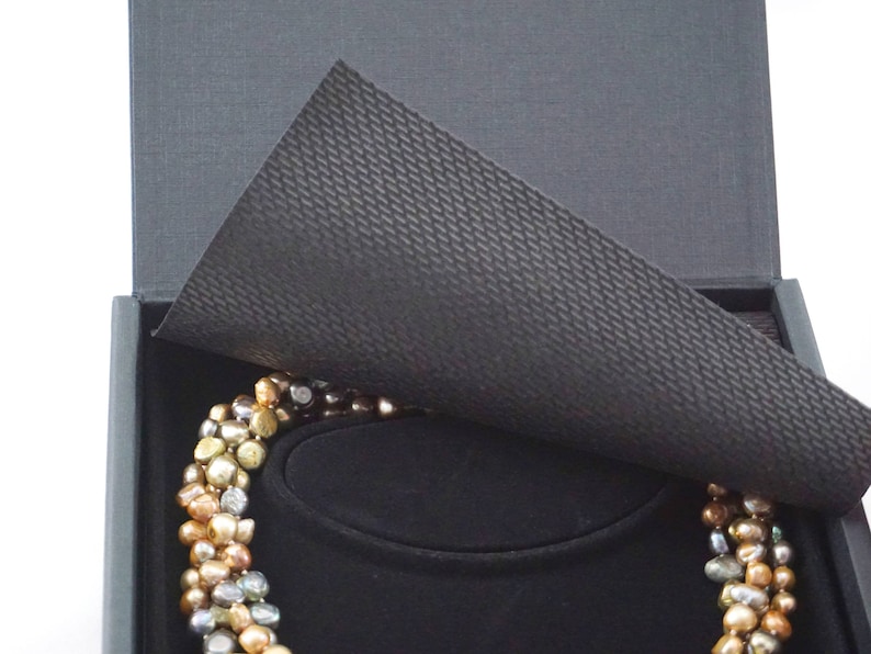 The box includes protective flaps of black material.