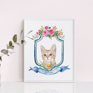 May include: A watercolour painting of a cat with a blue and white shield and a floral wreath. The cat is looking at the viewer and has a name tag that says "Silver".
