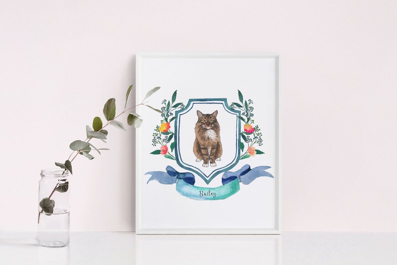 May include: A watercolour painting of a cat in a blue and green coat of arms with floral accents. The cat is sitting on a shield with the name "Bailey" written on a ribbon below.