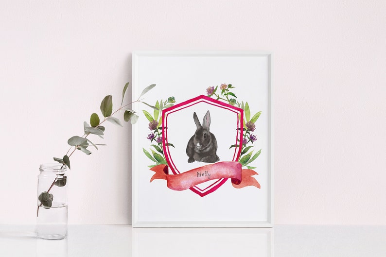 May include: A watercolour illustration of a black rabbit in a pink and white shield with a pink ribbon that says "Molly". The shield is surrounded by green leaves and pink flowers.