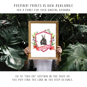 May include: A framed watercolour illustration of a black rabbit with pink ears and a red ribbon with the name "Melly" on it. The rabbit is surrounded by green leaves and flowers. The illustration is in a white frame with a wooden border.