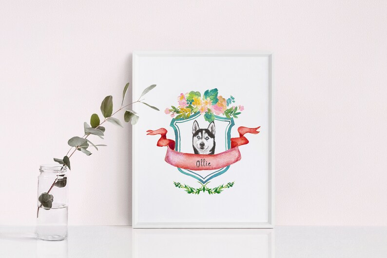 May include: A watercolour illustration of a husky dog with a floral wreath around its head. The dog is inside a teal shield with a red ribbon and the name "Ollie" written on it.