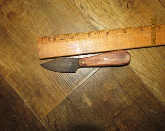 Item #29. Neck /Patch knife. Hammered 1095 metal. Wood handle with brass pins. Sheath covered with goat skin.